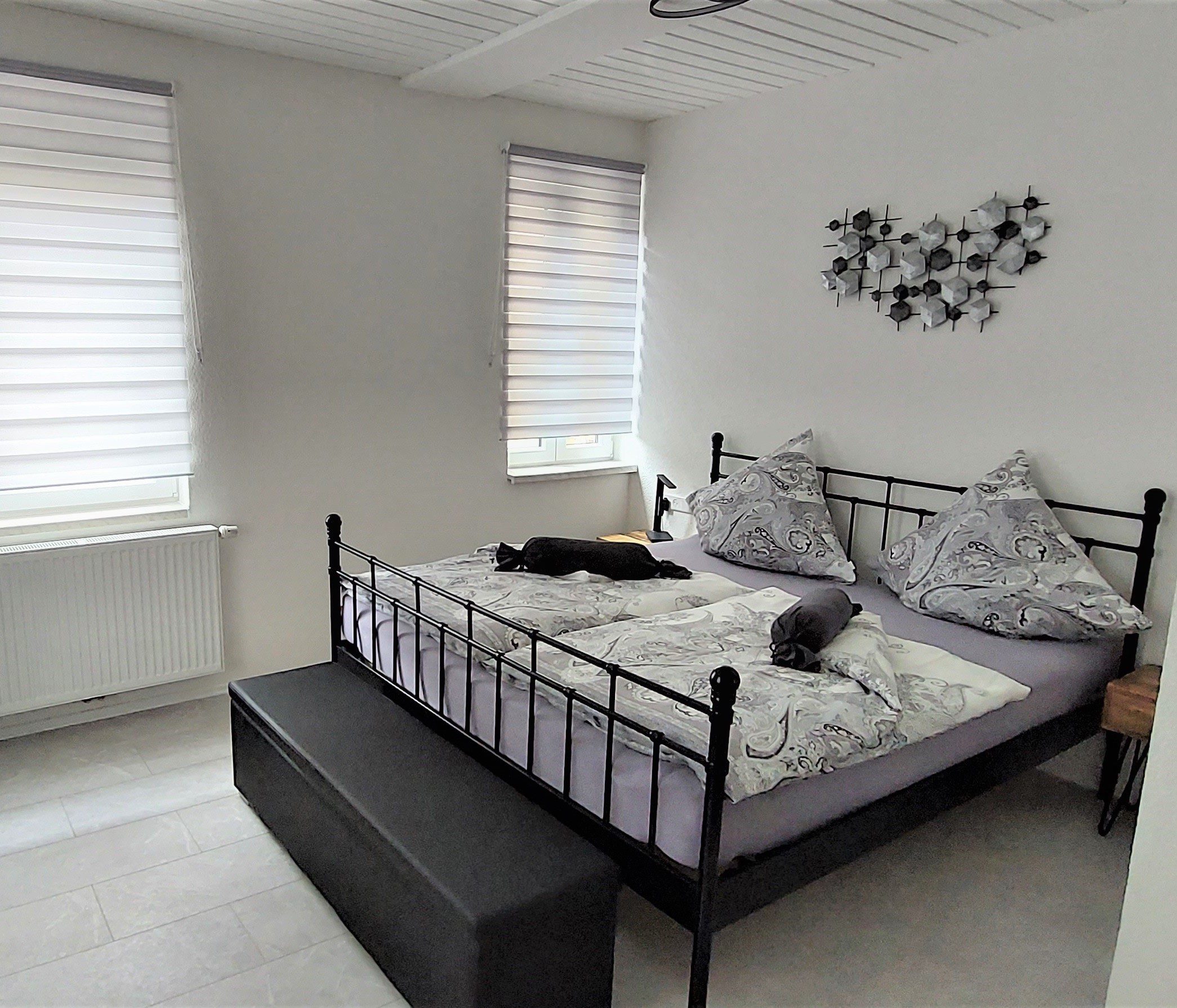 Gemütliches Doppelbett mit Deko und Tageslicht in der Ferienwohnung Tuttlingen Hill43
